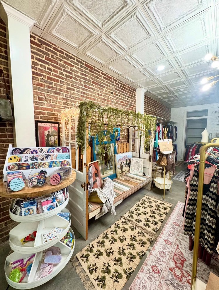 Wide view of the boutique interior with brick walls and rugs